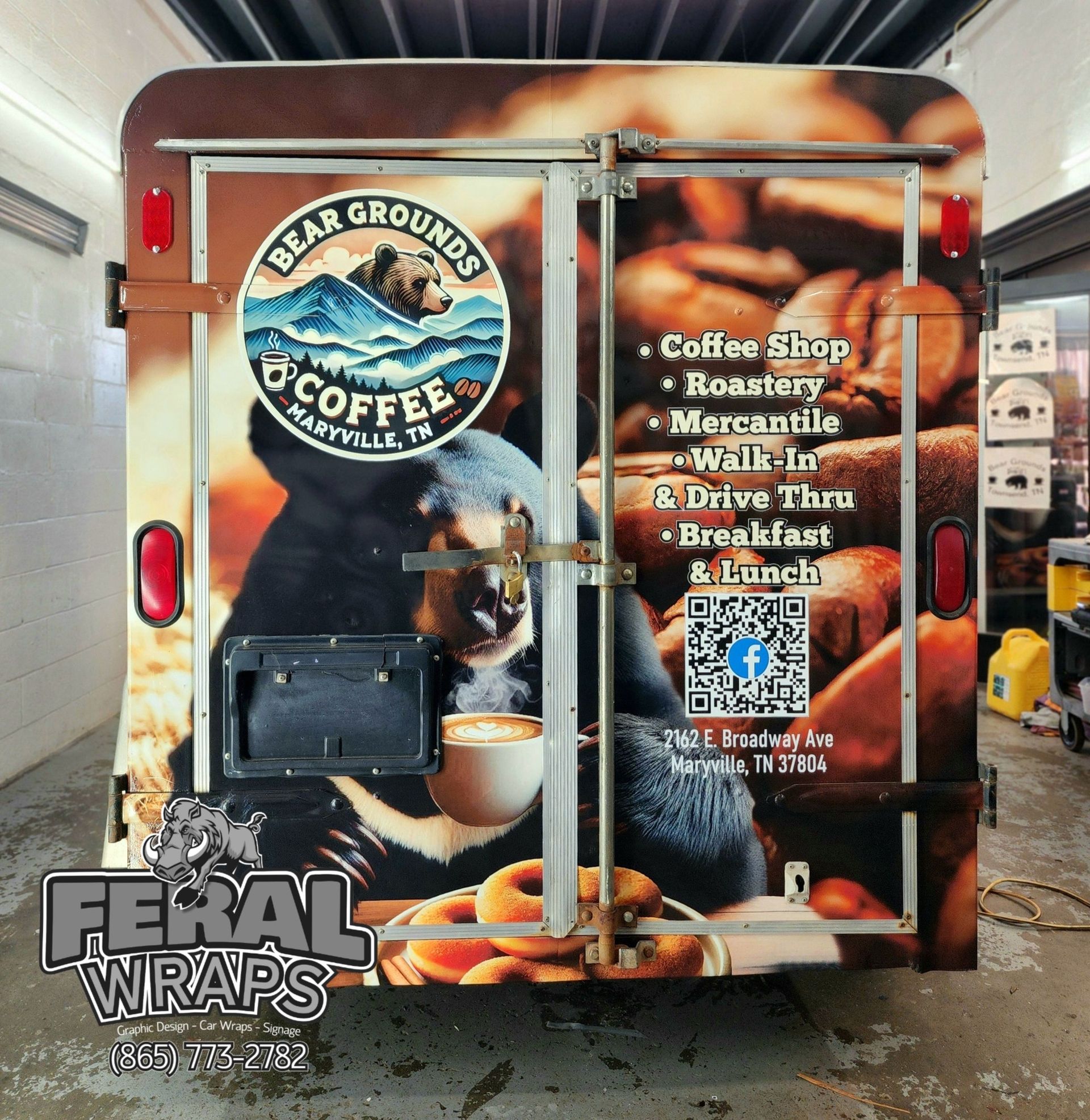 A bear grounds coffee truck is parked in a garage