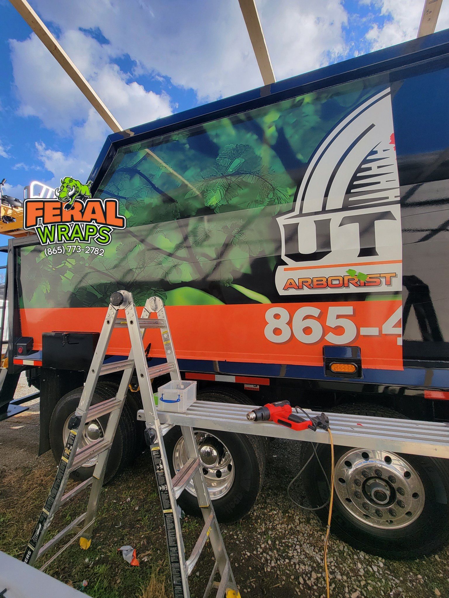 A trailer with a ladder attached to it is parked in a field.