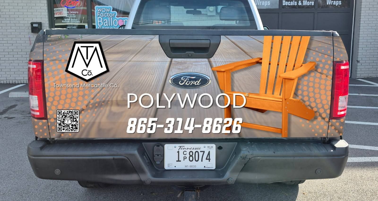 A truck with a wooden chair on the back is parked in a parking lot.