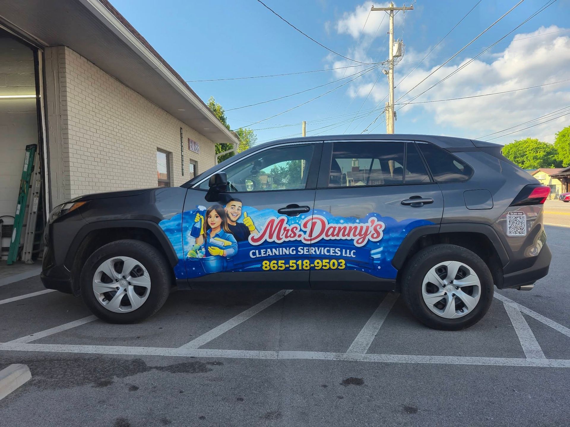 Branded SUV parked outside a building with Ms. Dany’s logo and phone number on the door