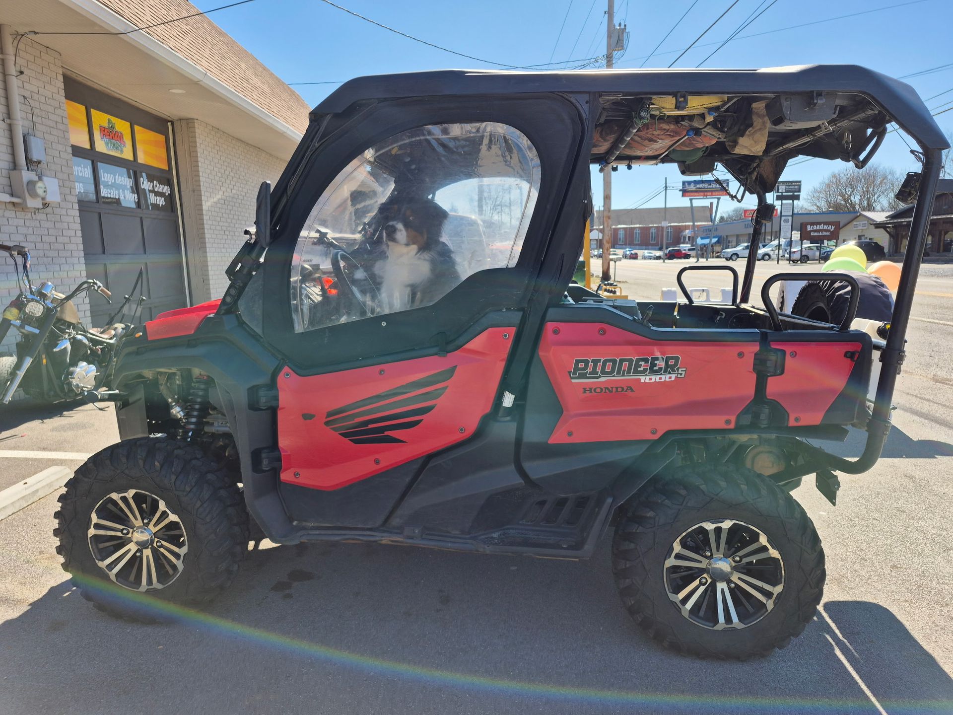 A red atv is parked in front of a building.