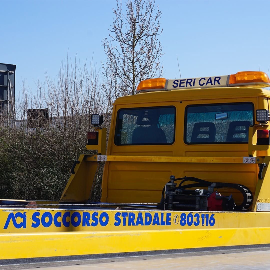 Carro attrezzi giallo per assistenza stradale con la scritta 