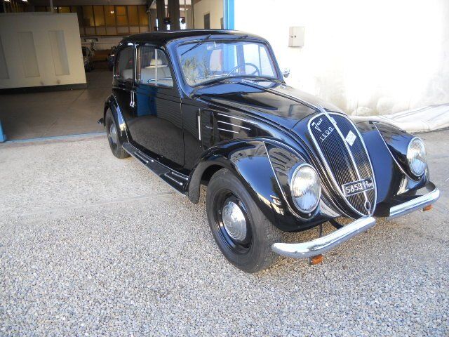 Maggiolino Volkswagen d'epoca nero parcheggiato in un garage, vista frontale.