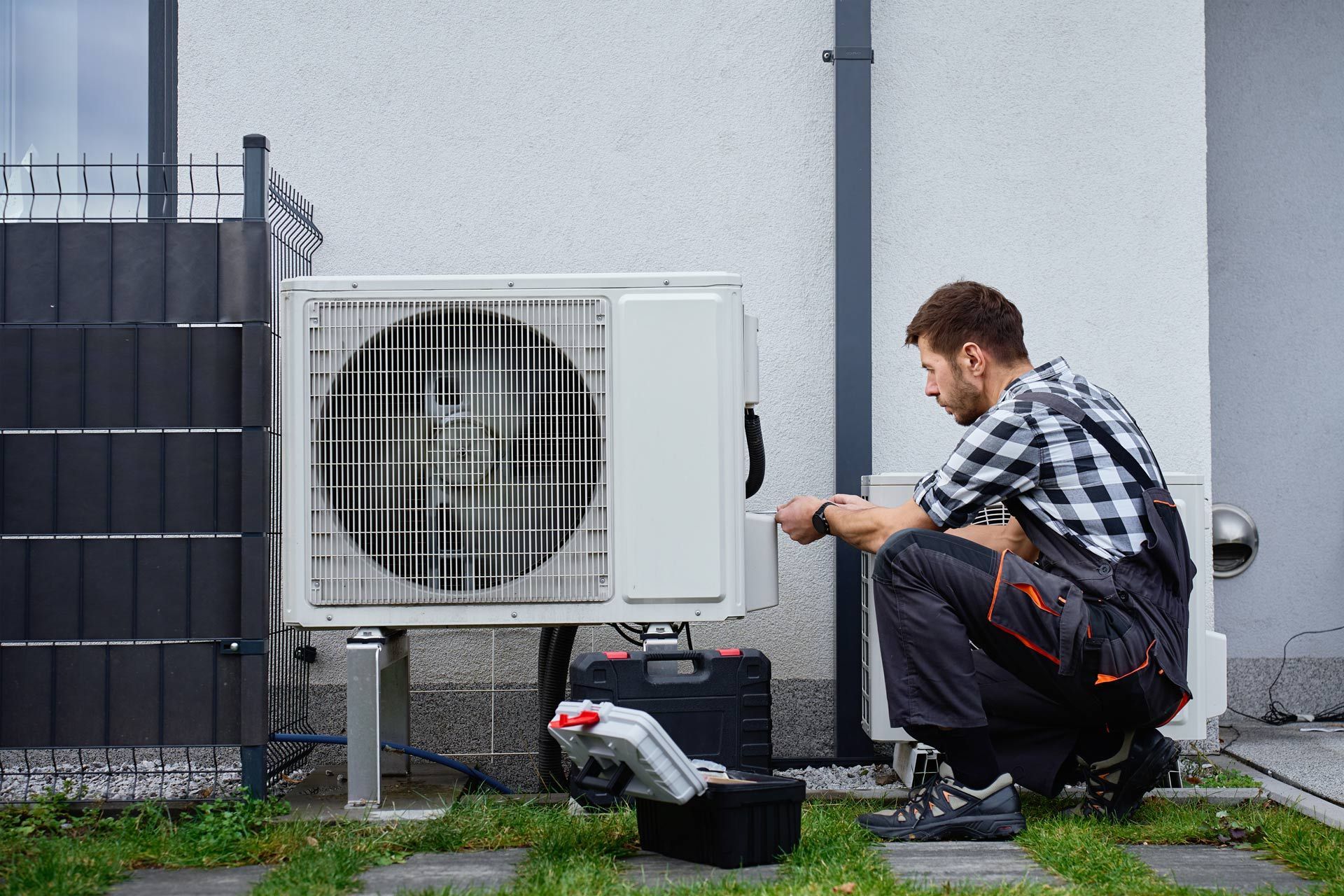 HVAC technician repairing an outdoor air conditioning condenser unit