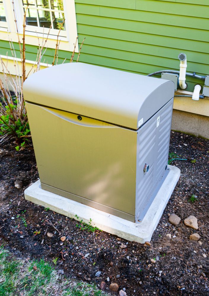 Outdoor gray utility box on a concrete pad beside a green house wall