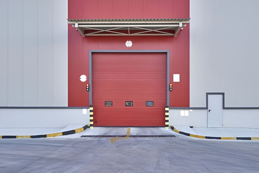 A Red Garage Door Is Open On The Side Of A Building — Brunswick Valley Door Centre in Northern Rivers, NSW