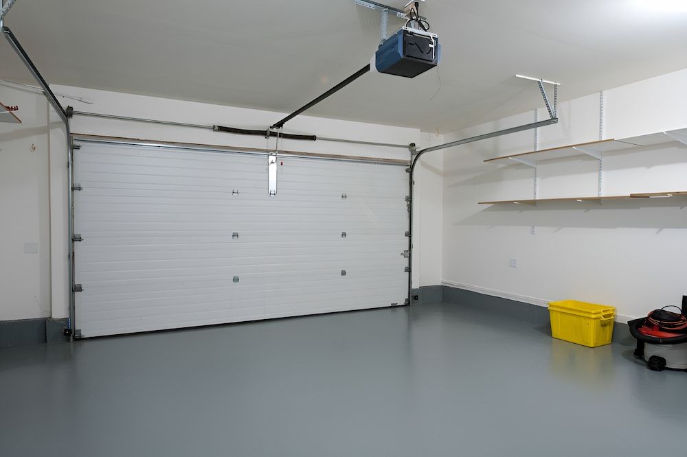 An Empty Garage With A Garage Door Open And A Garage Door Opener — Brunswick Valley Door Centre in Main Arm, NSW