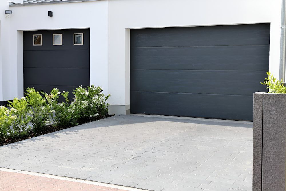 There Are Two Garage Doors In Front Of A House — Brunswick Valley Door Centre in Ballina, NSW