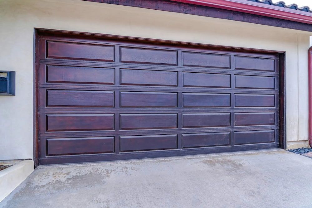 A Large Wooden Garage Door Is Sitting On The Side Of A House — Brunswick Valley Door Centre in Lismore, NSW