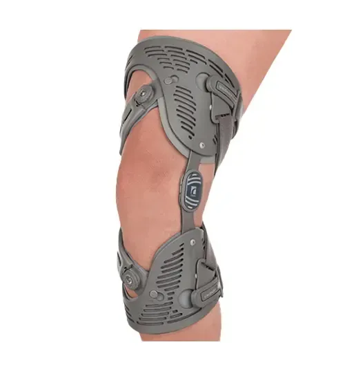 A gray, rigid orthopedic knee brace worn on a human leg to provide structural support and stabilization.