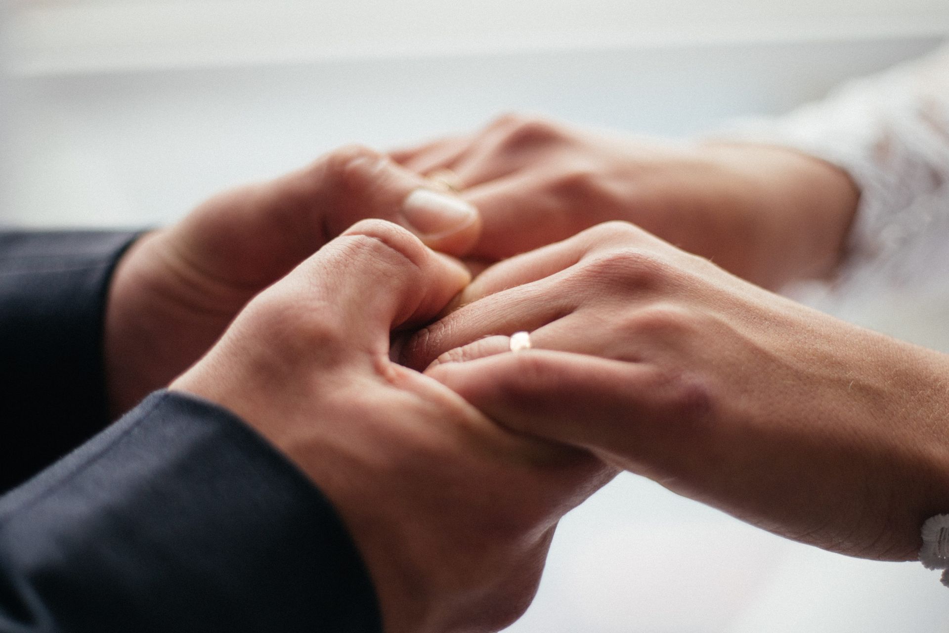 Hands placing a ring on a finger during a wedding ceremony
