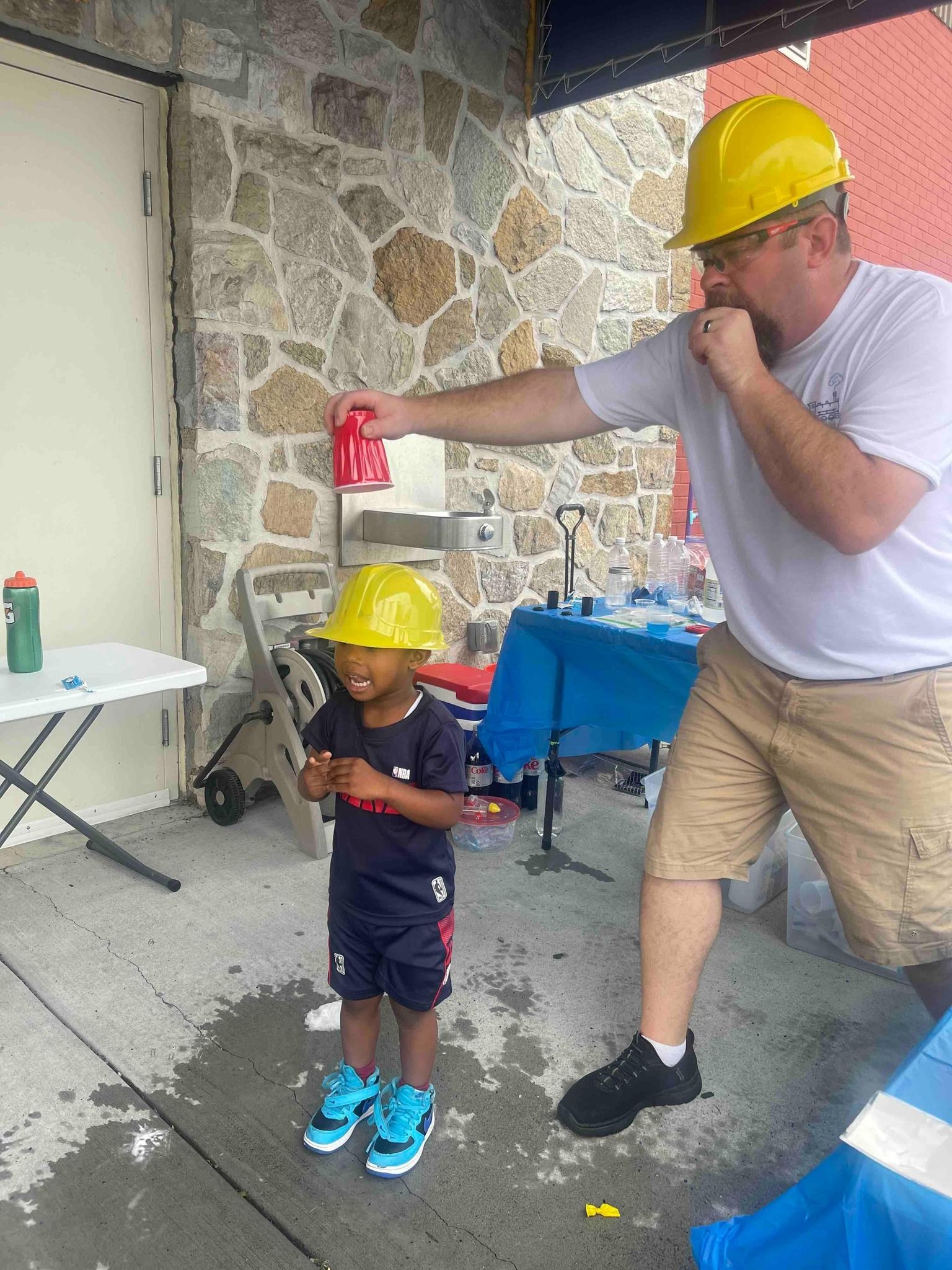 holding 'water' over a kids hat