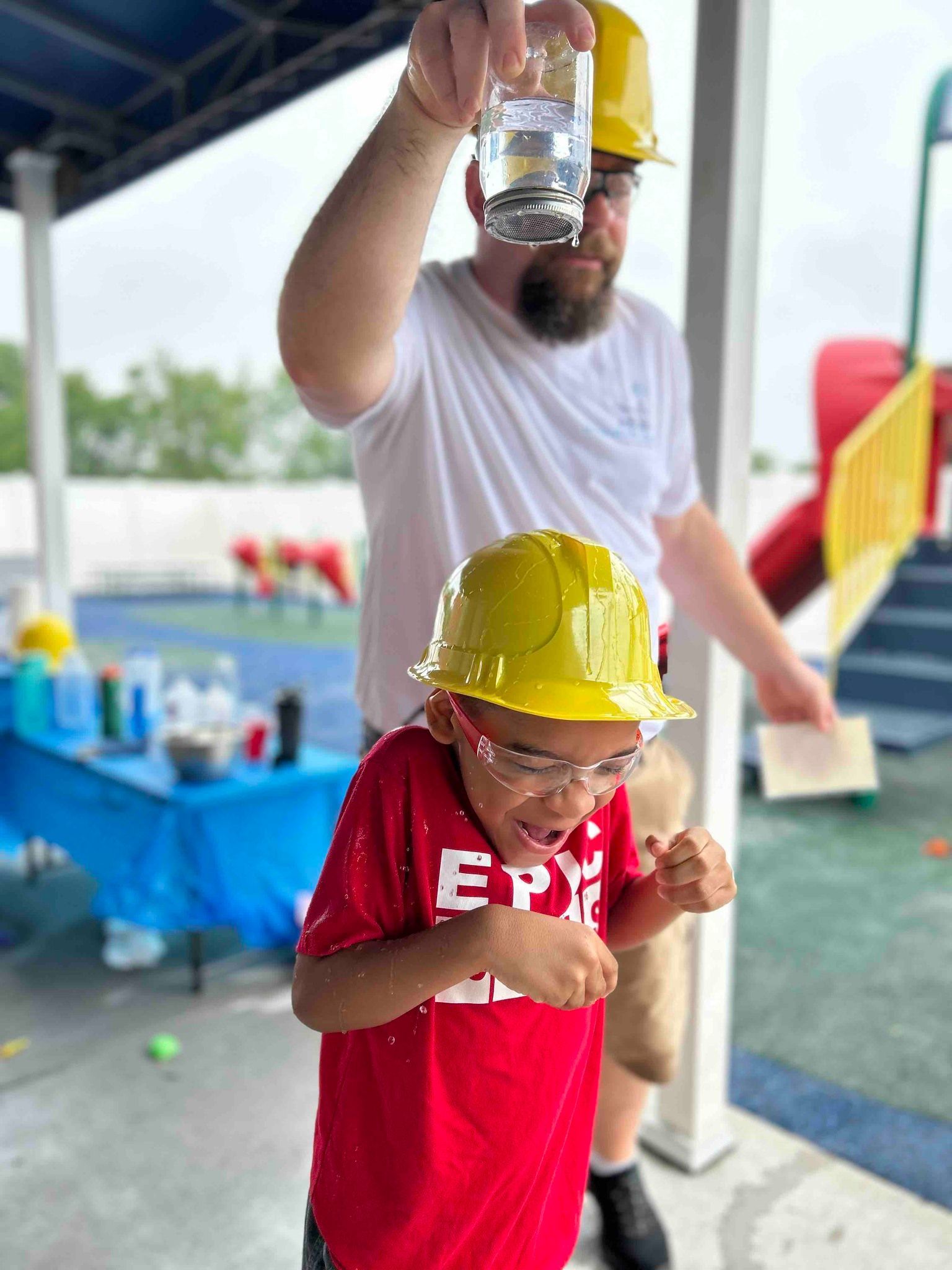 holding jar of water over construction hat