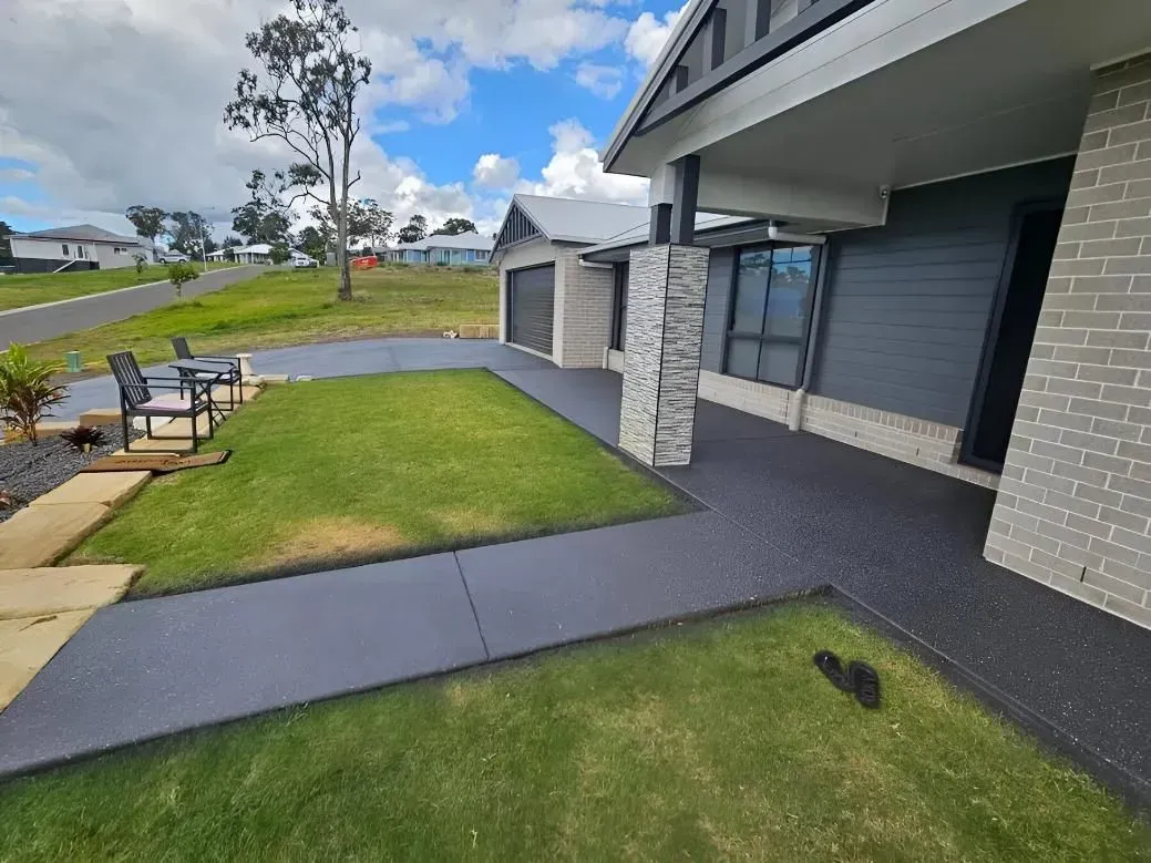 Modern Home Exterior With Grey Paved Walkway, Green Grass, and Blue Sky — SRS Concreting In Ipswich, QLD