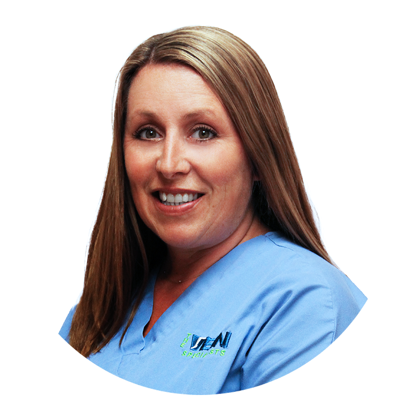 A woman in a blue scrub is smiling for the camera.