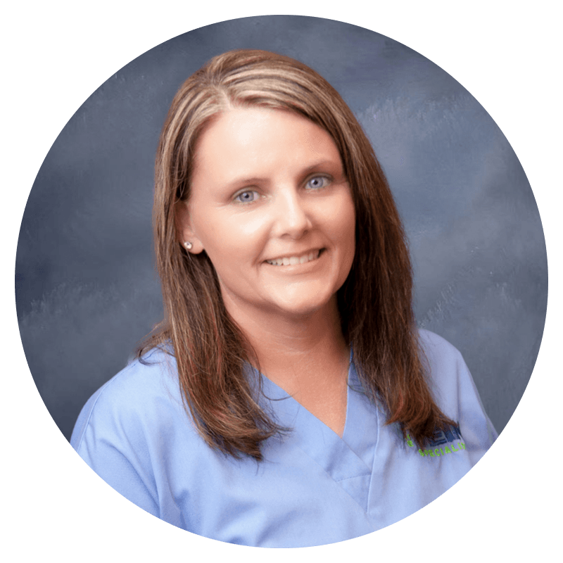 A woman in a blue scrub is smiling in a circle