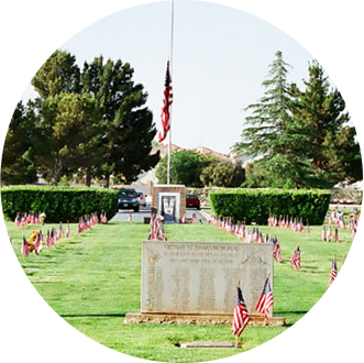 A grave in a cemetery with american flags around it