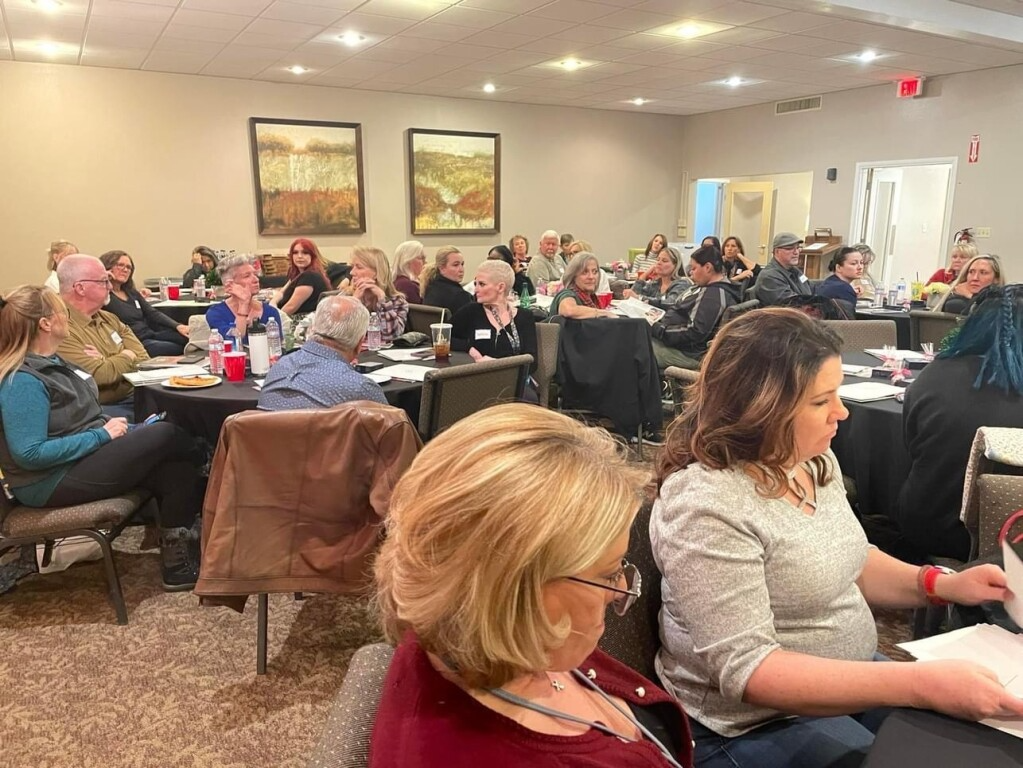 A large group of people are sitting at tables in a room.