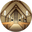 The inside of a church with a vaulted ceiling and wooden beams.