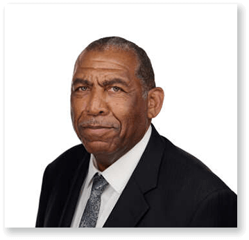 A man in a suit and tie is looking at the camera.