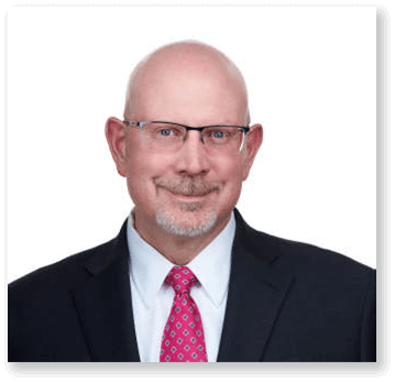 A man in a suit and tie is smiling for the camera.