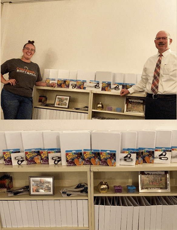 A man and a woman are standing in front of a shelf full of books