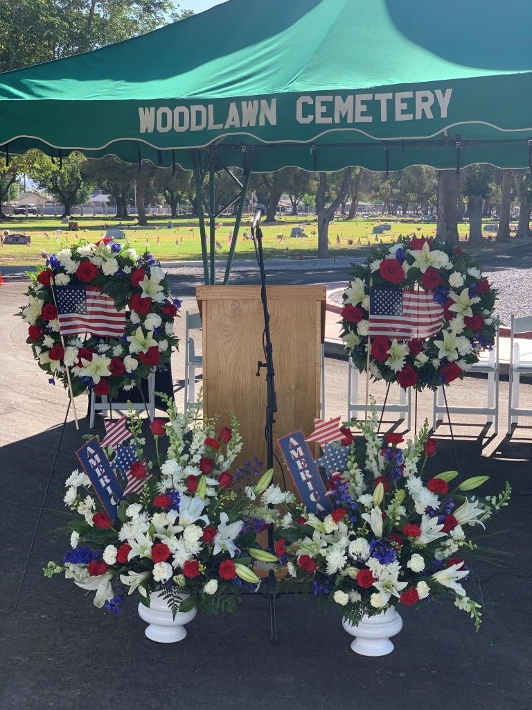 A woodlawn cemetery with a podium and flowers