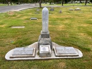 There is a grave in the middle of a cemetery.
