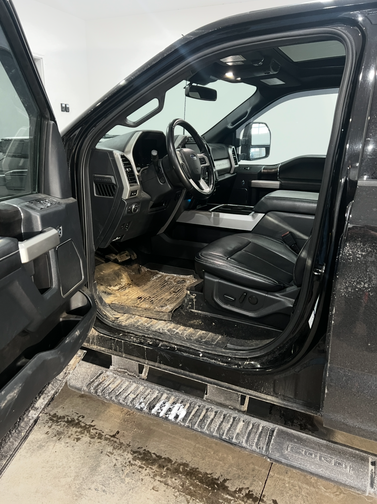 The inside of a black truck with the door open.