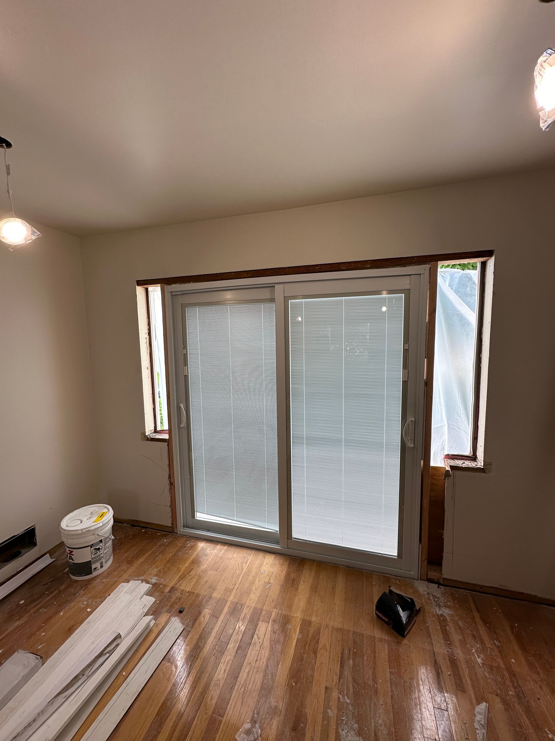 A room with a sliding glass door and blinds.