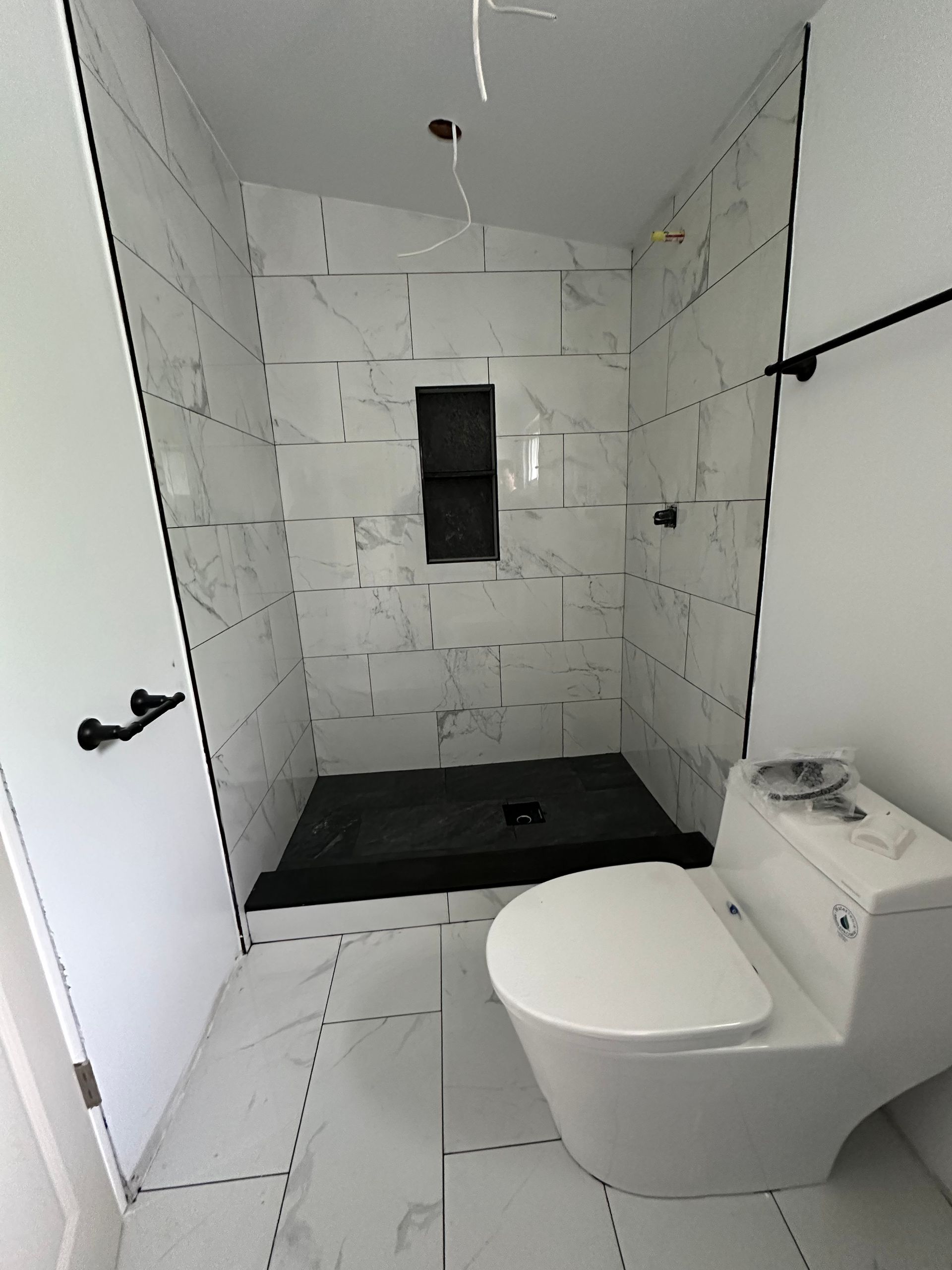 A bathroom with a toilet and a shower stall.