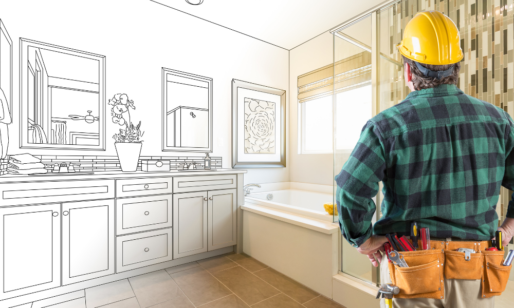 A construction worker is looking at a drawing of a bathroom being remodeled.