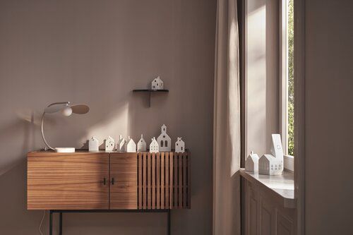 Moderne kamer met een houten kast, kleine decoratieve objecten en licht van een raam.