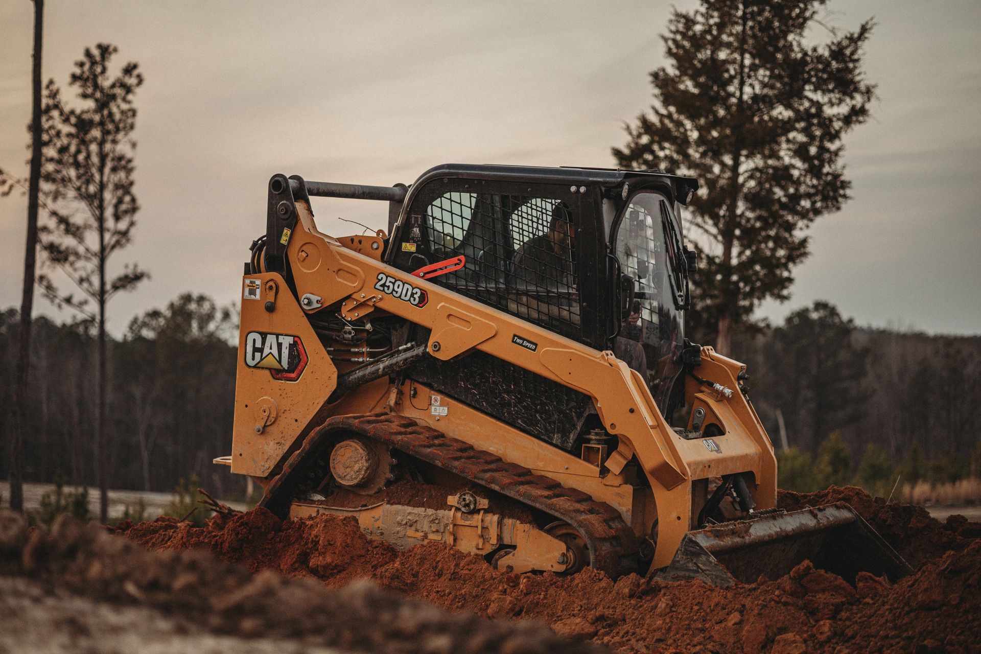 A bulldozer is driving through a dirt field.