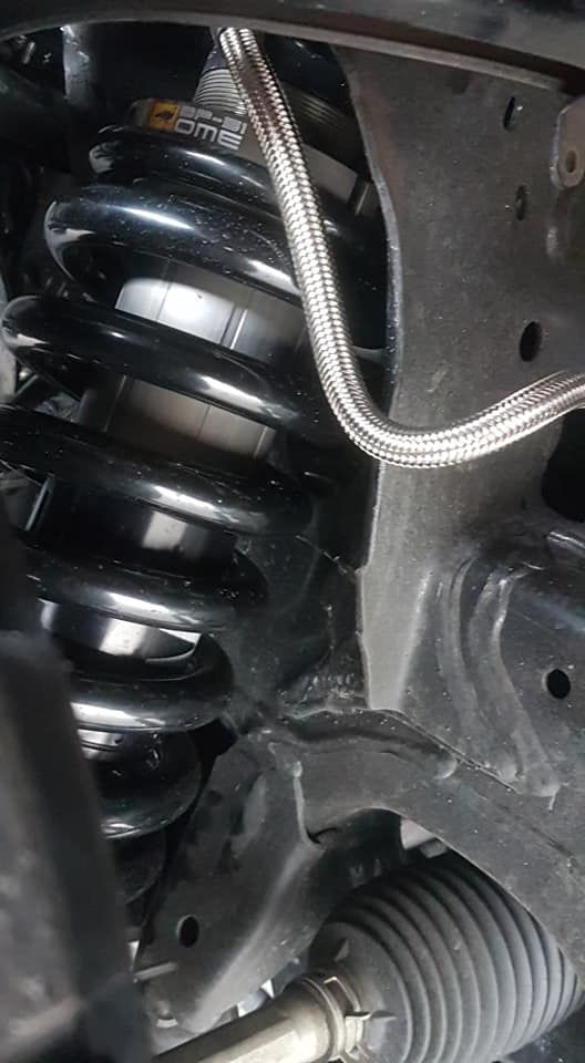 Close-up of a car suspension coil spring with a braided hose and wheel well components — Ol Mate 4x4 in Tuggerah, NSW