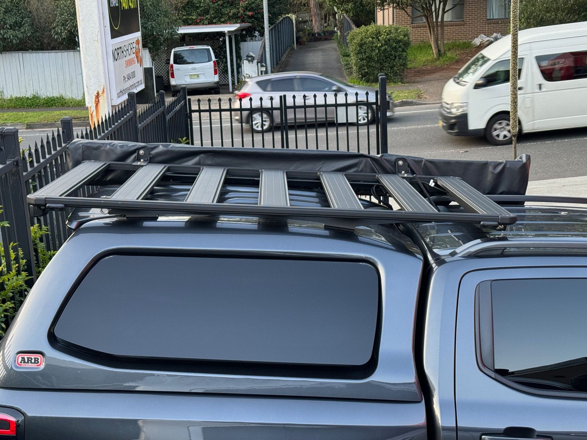 Gray pickup truck with a black roof rack parked on a street near a gate and white van — Ol Mate 4x4 in Tuggerah, NSW