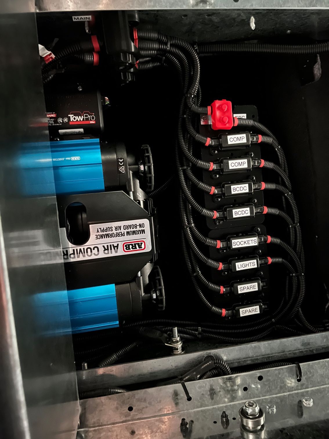 Electrical panel with blue components and a row of labelled black breakers with red switches — Ol Mate 4x4 in Tuggerah, NSW