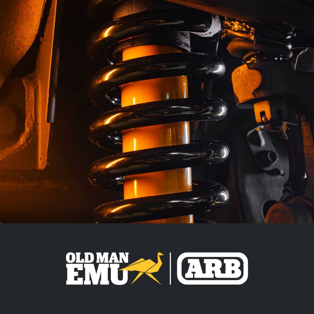Close-up of an orange off-road suspension coil with Old Man Emu and ARB logos on black background — Ol Mate 4x4 in Tuggerah, NSW