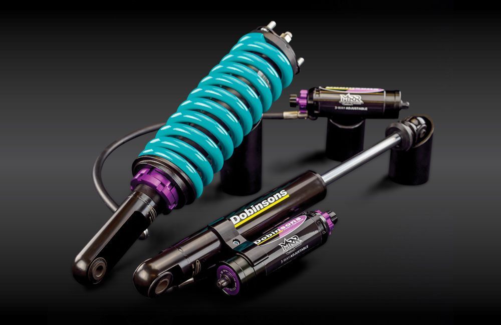 Turquoise coilover suspension kit with black shocks on a dark background — Ol Mate 4x4 in Tuggerah, NSW
