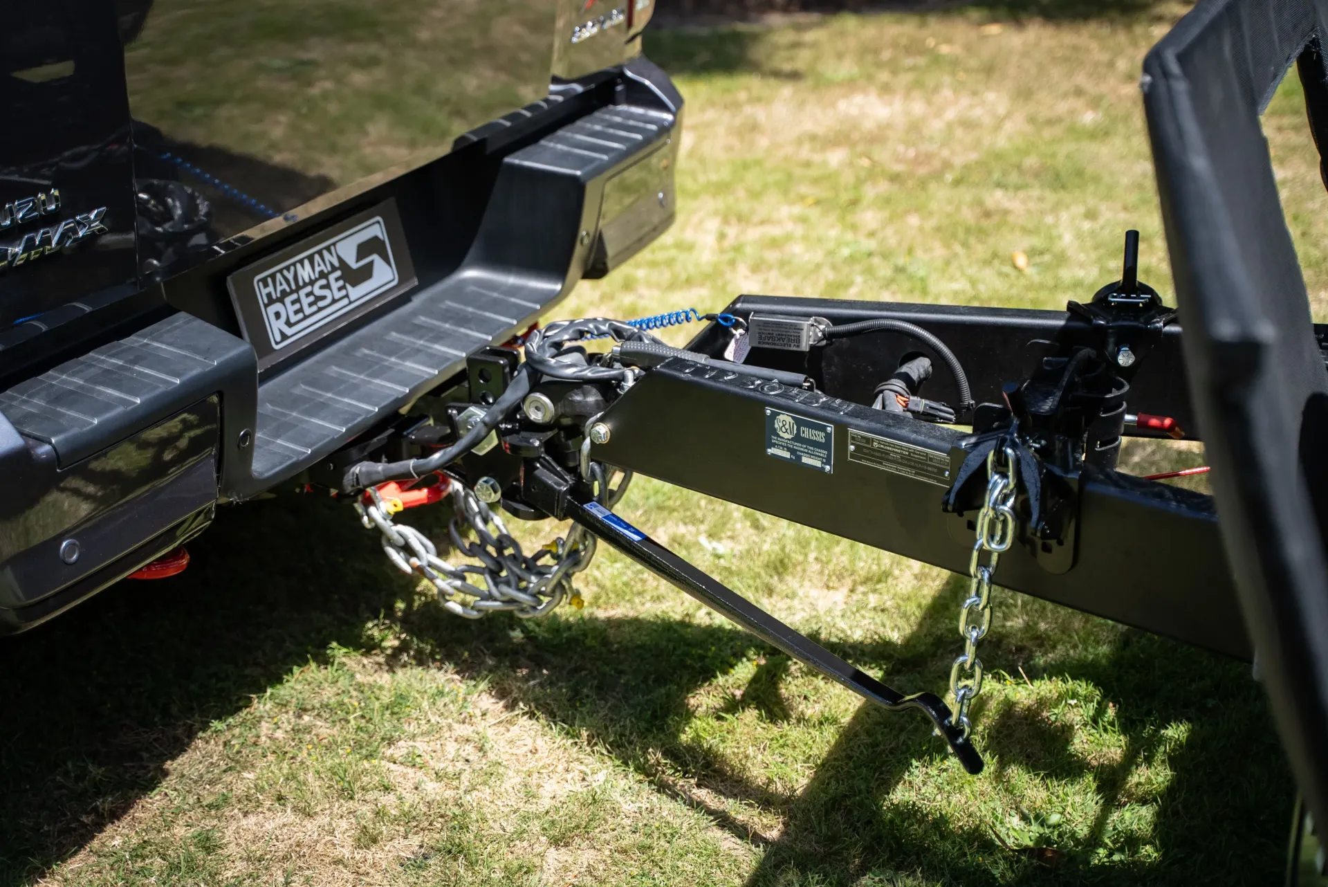 Black trailer hitch and metal frame resting on grass in an outdoor yard— Ol Mate 4x4 in Tuggerah, NSW