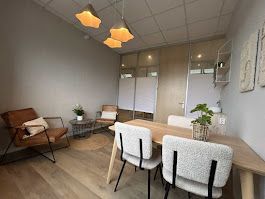 Gezellige kantoorruimte met een tafel en stoelen, een loungehoek met fauteuils en sfeerverlichting.