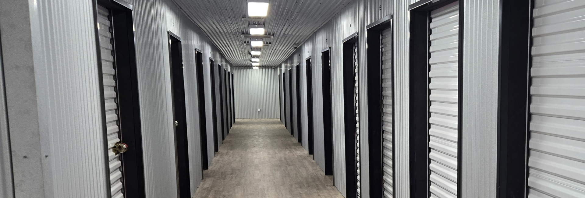 Indoor climate controlled self storage hallway with secure clean units and bright lighting