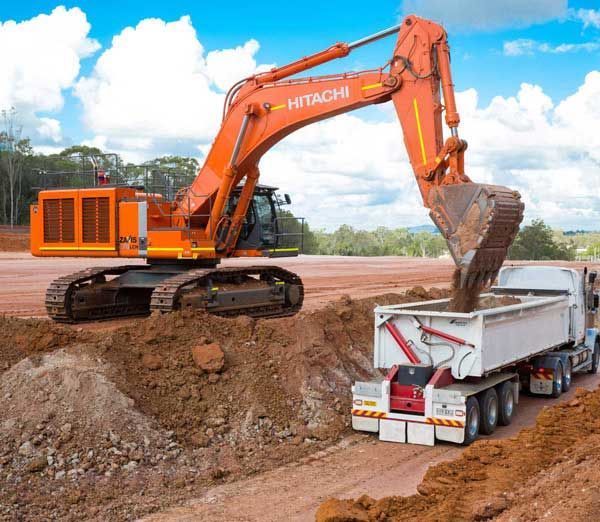 An excavator is loading dirt into a dump truck.