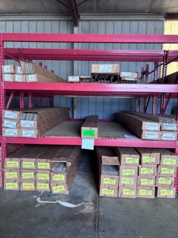Warehouse racks stacked with long wooden planks wrapped in plastic labels