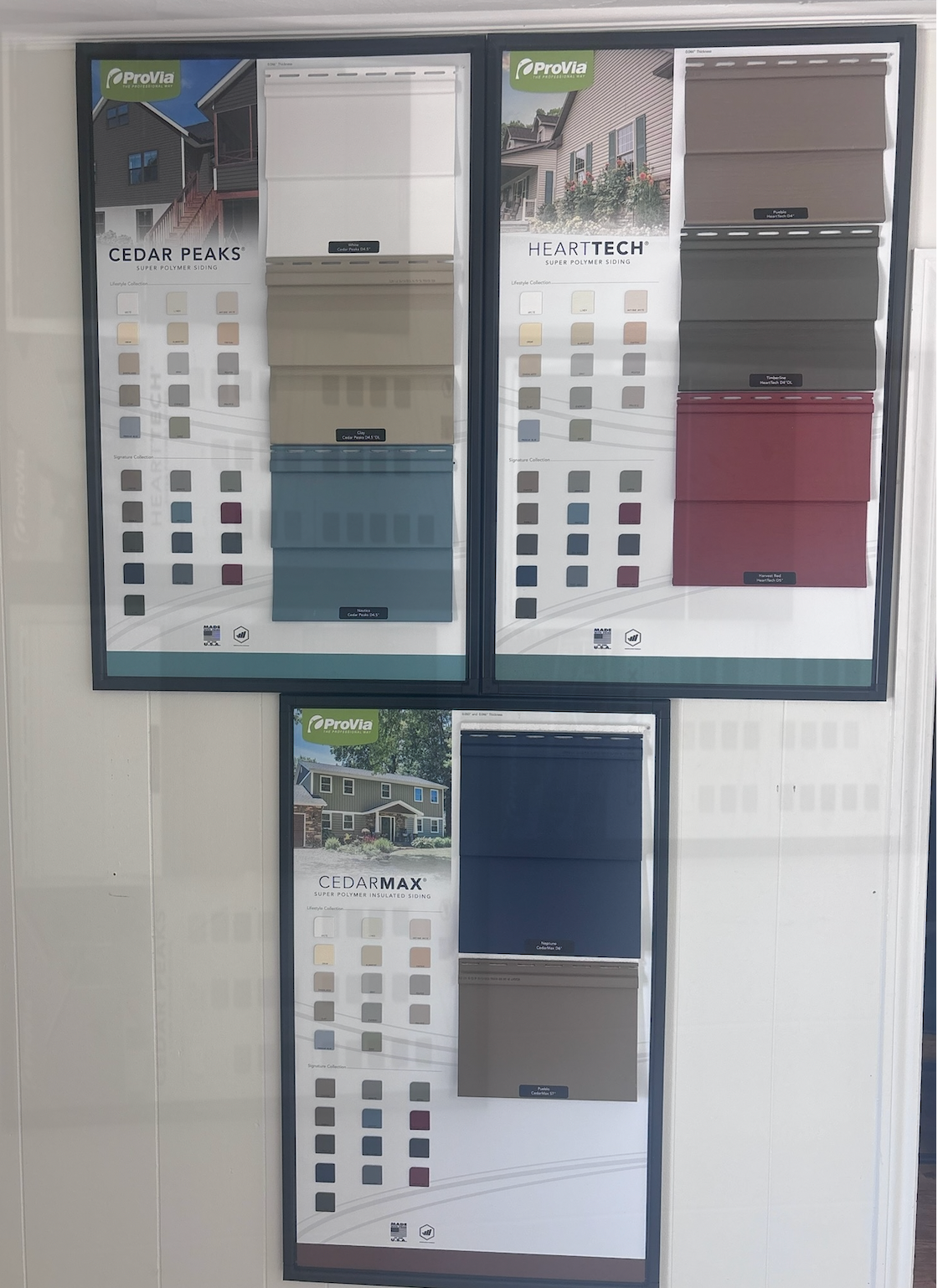 Display of paint color samples and brochures on a wall, with beige, blue, gray, and maroon swatches.