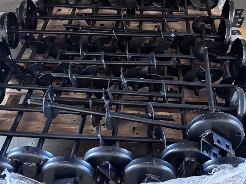 Stacks of black wheeled metal carts or frames piled in a storage area