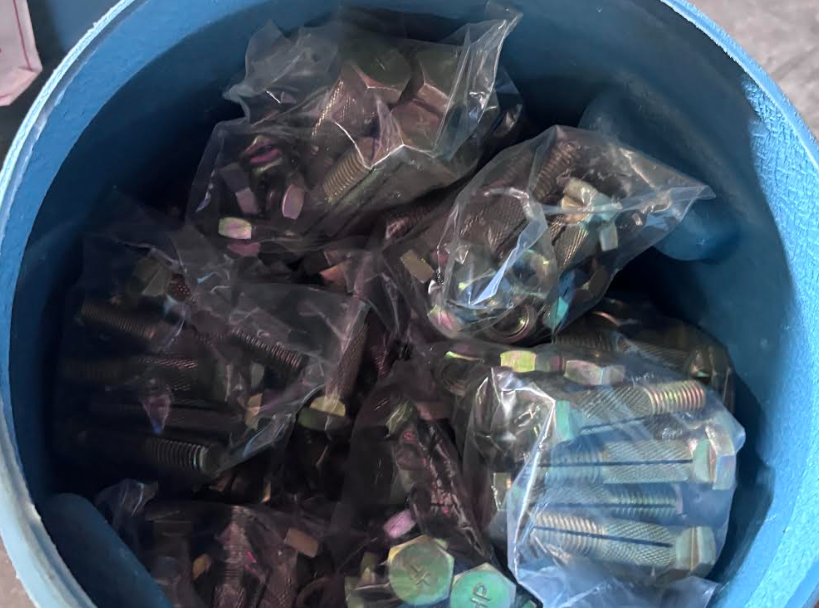 Blue bucket filled with assorted small packaged items in clear plastic bags