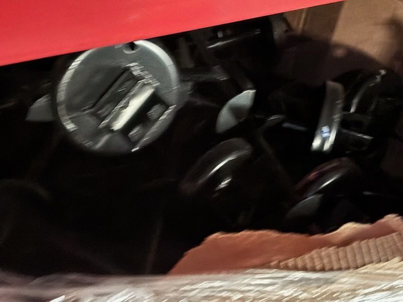 Close-up of a red dashboard with a circular gauge and black controls in a vehicle interior