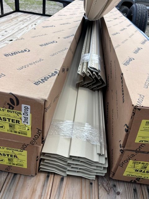 Stacked cardboard building materials in open boxes on a wooden deck