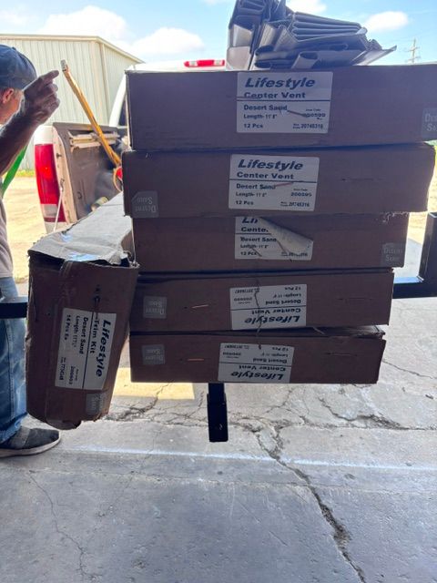 Stacked LifeStraw water filter boxes being unloaded from a vehicle in a warehouse driveway